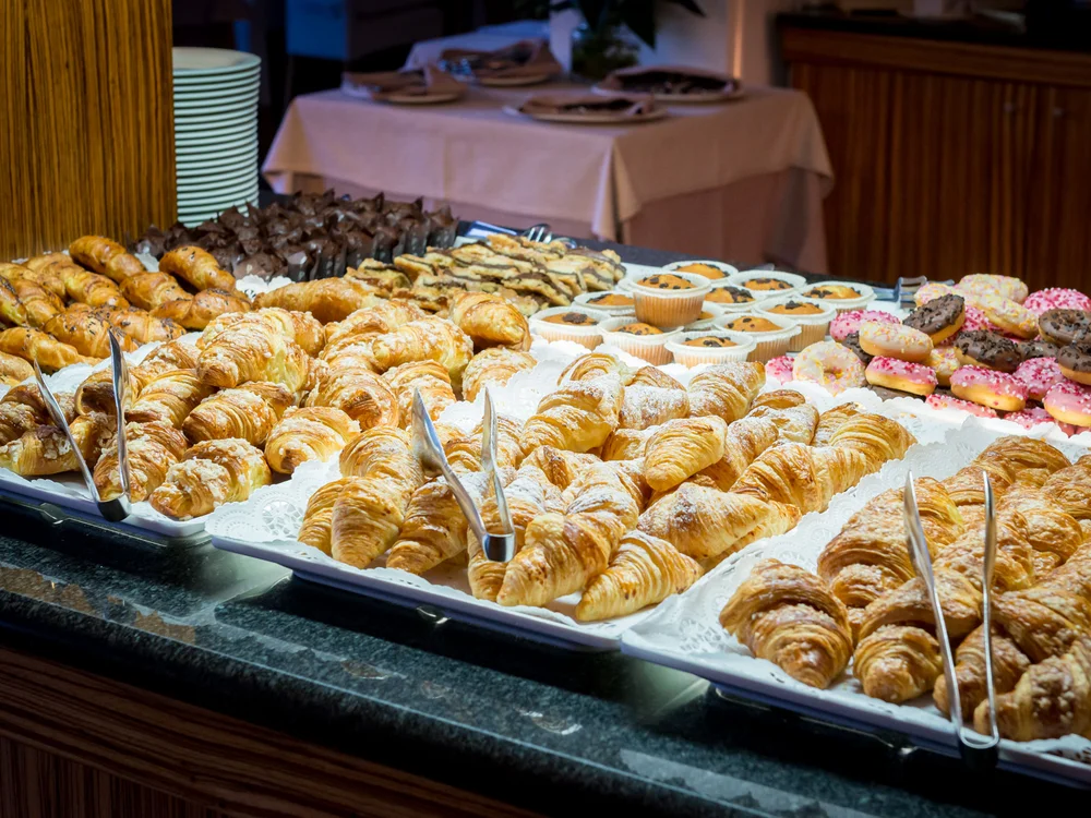 Bibione Palace Hotel · La tua casa al mare a 4 stelle S Vassoi di croissant e dolci assortiti su un bancone da buffet