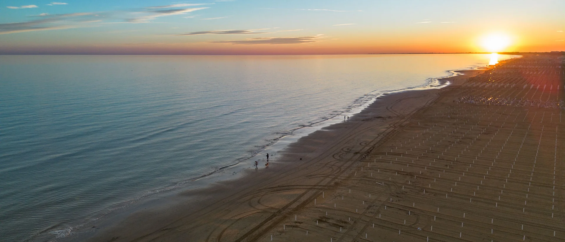 Bibione Palace Hotel · La tua casa al mare a 4 stelle S Spiaggia al tramonto con mare calmo e cielo sereno