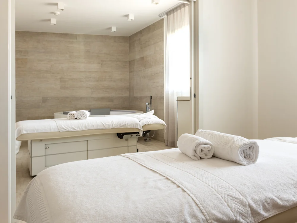 Bibione Palace Hotel · La tua casa al mare a 4 stelle S Camera spa con due lettini per massaggi e asciugamani arrotolati bianchi