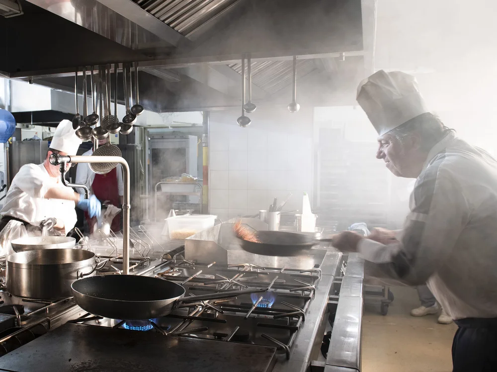 Bibione Palace Hotel · La tua casa al mare a 4 stelle S Cuochi professionisti che cucinano in una cucina di ristorante fumante