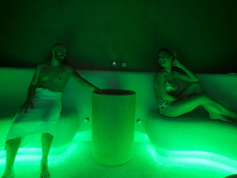 Bibione Palace Hotel · La tua casa al mare a 4 stelle S Uomo e donna rilassati in sauna con illuminazione verde soffusa