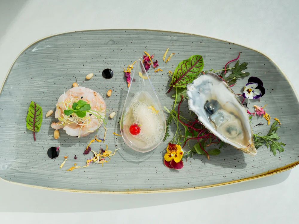 Bibione Palace Hotel · La tua casa al mare a 4 stelle S Piatto gourmet con ostrica, gamberi, salsa e decorazioni floreali