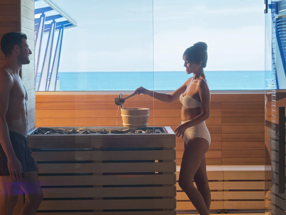 Bibione Palace Hotel · La tua casa al mare a 4 stelle S Coppia in costume da bagno nella sauna con vista sul mare