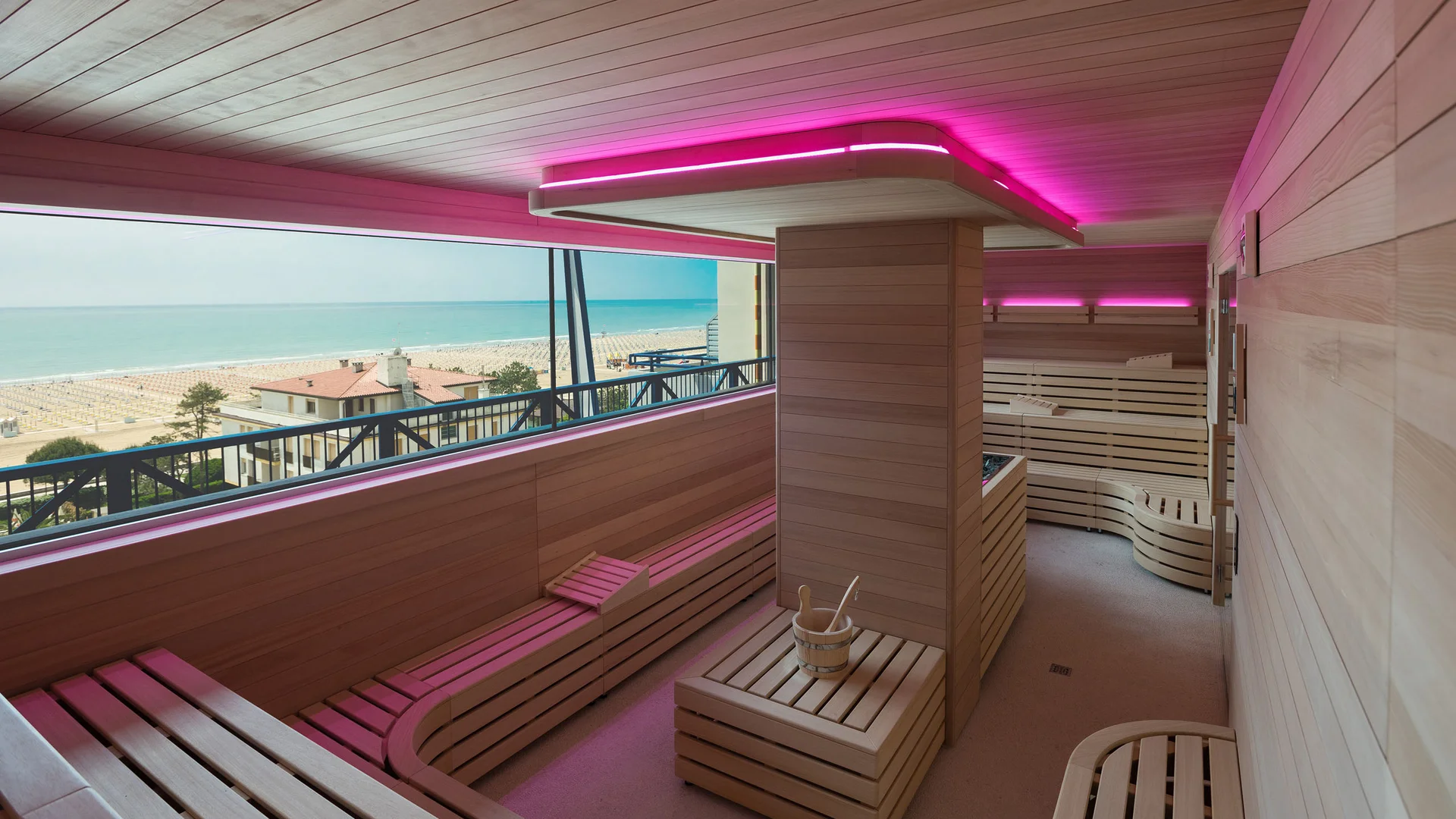 Sauna moderna con vista sul mare e luci rosa al soffitto