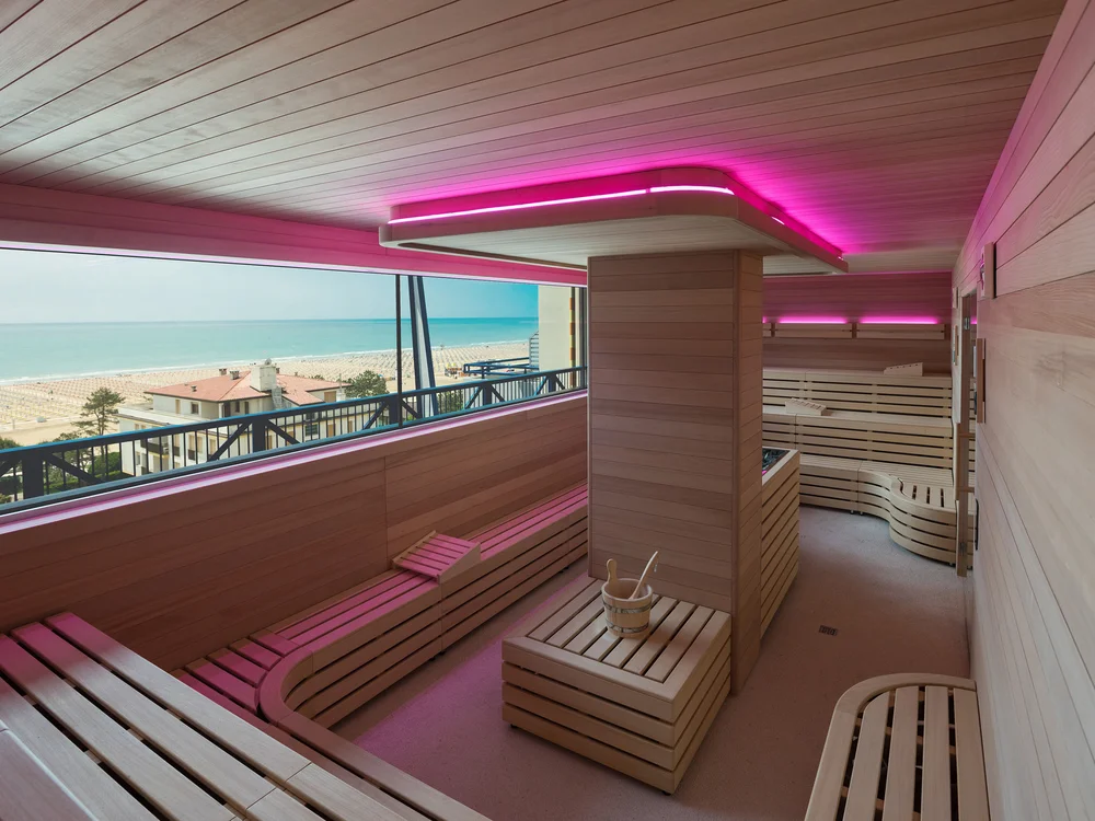 Bibione Palace Hotel · La tua casa al mare a 4 stelle S Sauna moderna con vista sul mare e luci rosa al soffitto
